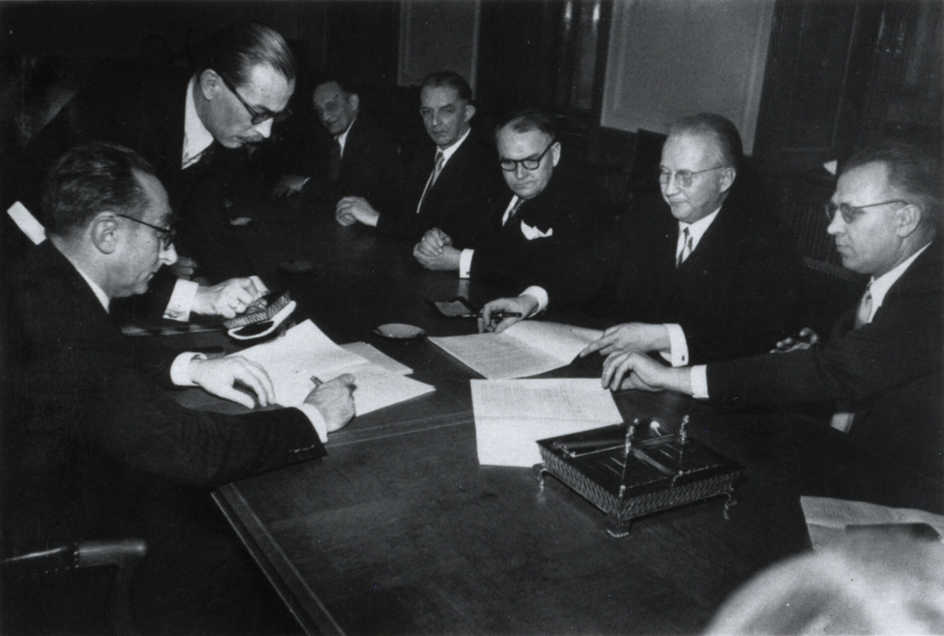 Unterzeichnung des Jochenstein-Abkommens im Bundesministerium für Verkehr und verstaatlichte Betriebe in Wien am 13. Februar 1952 durch den österreichischen Minister Karl Waldbrunner (ganz links), Bundesverkehrsminister Christoph Seebohm (gegenüber sitzend) und den bayerischen Staatsminister der Finanzen Friedrich Zietsch (ganz rechts); neben Minister Waldbrunner stehend der Leiter der Protokollabteilung der Bayerischen Staatskanzlei, Philipp Frhr. von Brand<br/>Nachweis: MF 87902.