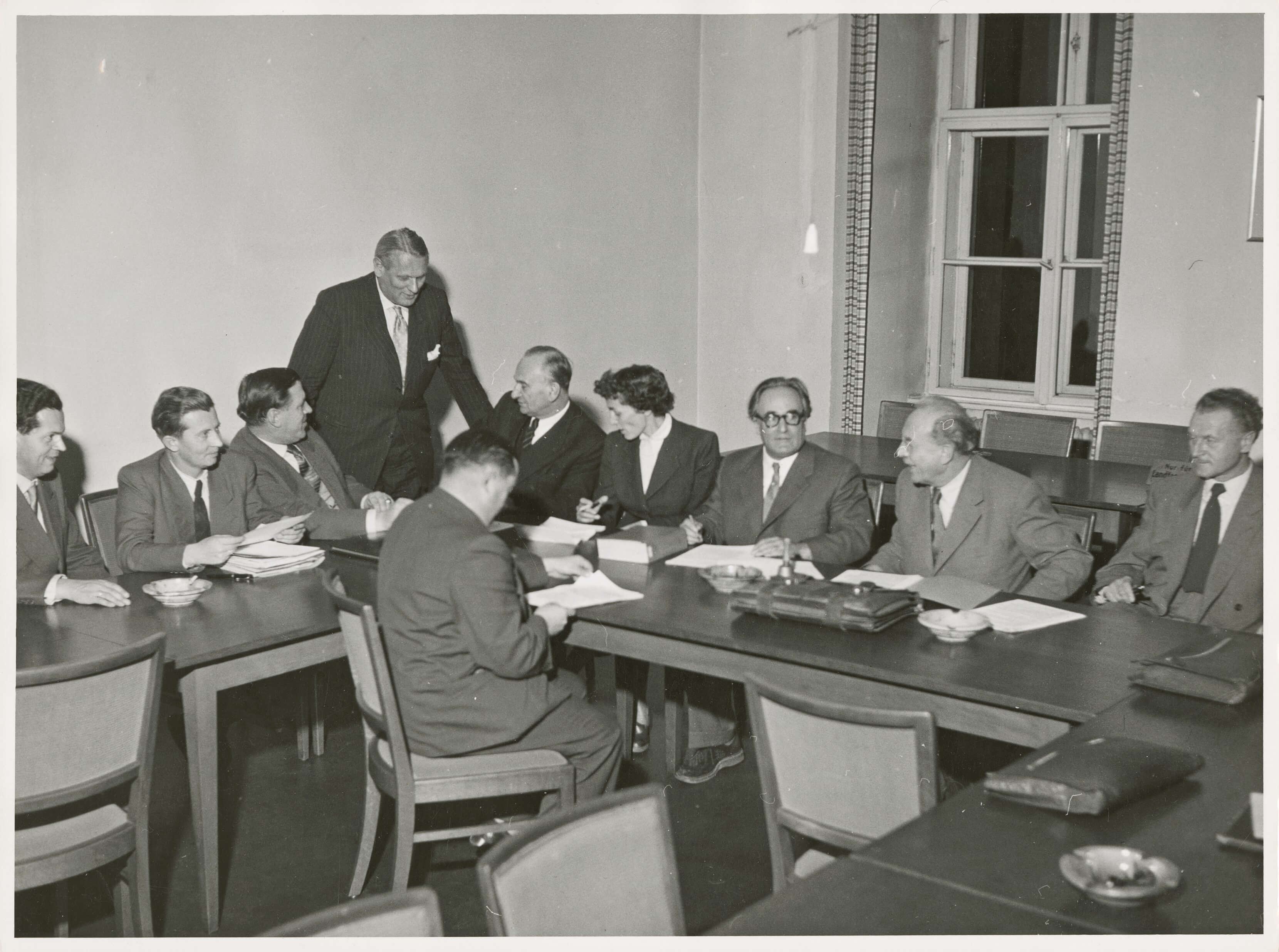 Blick in das Konferenzzimmer des Bayerischen Landtags am 9. Dezember 1954 mit einer größeren Verhandlungsrunde der vier künftigen Koalitionsparteien. Von links nach rechts: Der bayerische BHE-Bundestagsabgeordnete Wilfried Keller, Walter Stain (BHE), MdL Max Klotz (BP), Albrecht Haas (FDP), Otto Bezold (FDP), Hildegard Brücher (FDP), Joseph Baumgartner (BP), Wilhelm Hoegner (SPD) und Waldemar von Knoeringen (SPD).<br/>Nachweis: StK-Fotos 107/2